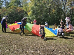 Individuals outside playing with a large canvas activity.